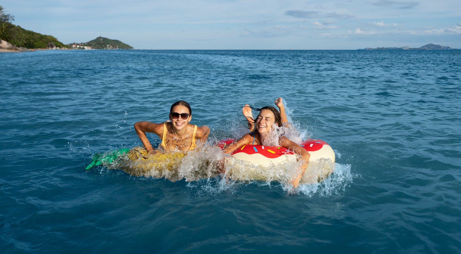 Девушки купаются в море.