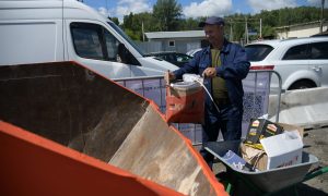 Мужчина выбрасывает мусор