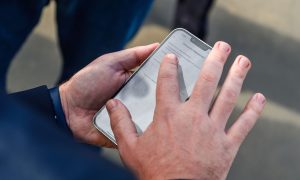 Мужчина отправляет жалобу в телефоне