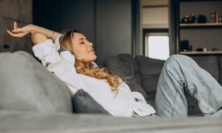 Девушка потягивается, отдыхая на диване.