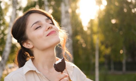 Девушка наслаждается мороженым и солнечным светом.