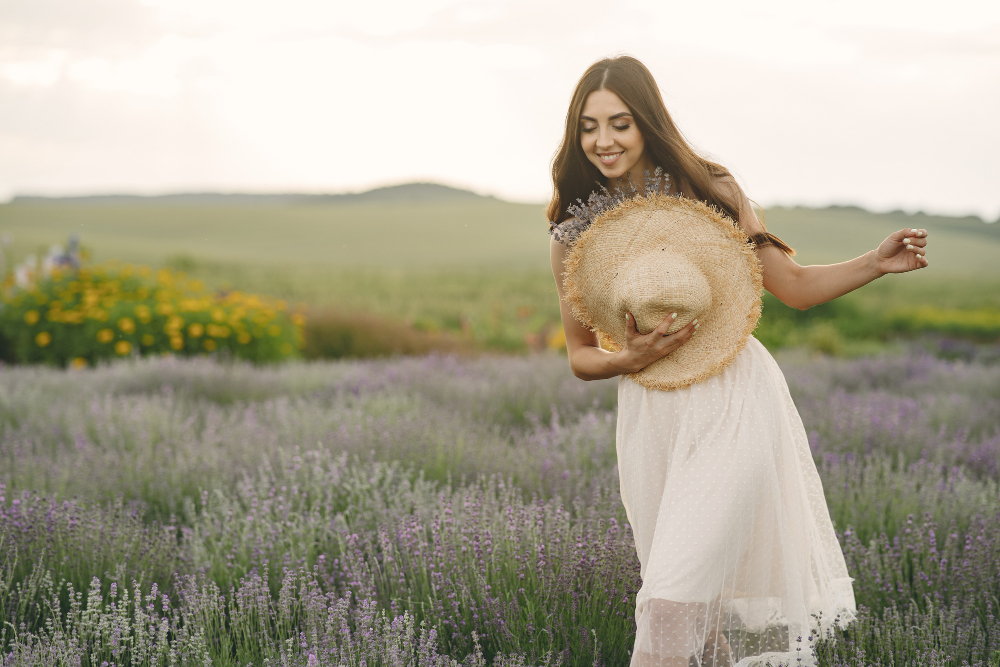 Счастливая девушка идет по цветущему полю.