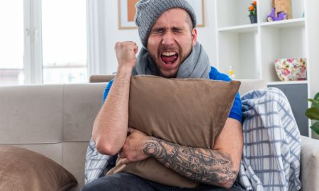 Парень разъярен и прижимает к себе подушку.