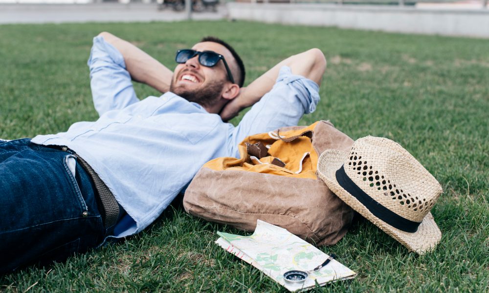 Парень лежит в парке на траве.