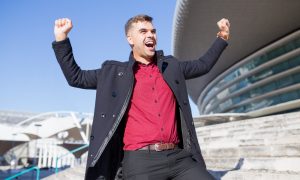 Парень кричит от радости на улице.