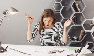 Девушка сидит за столом в офисе.