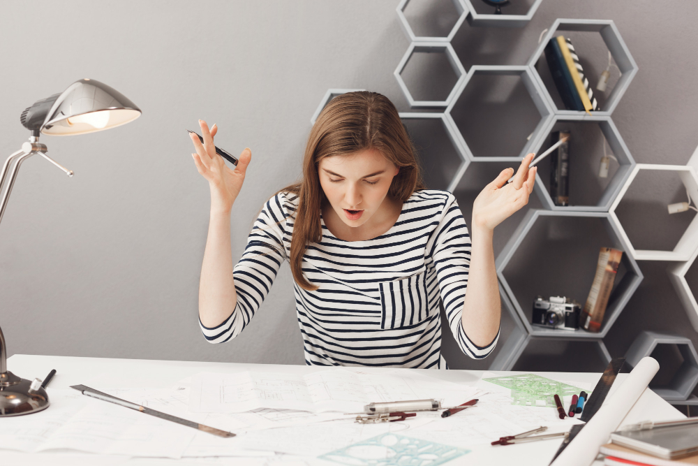 Девушка сидит за столом в офисе.