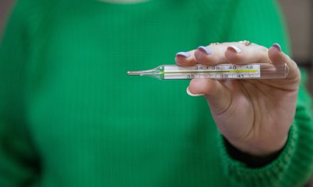 Девушка держит термометр