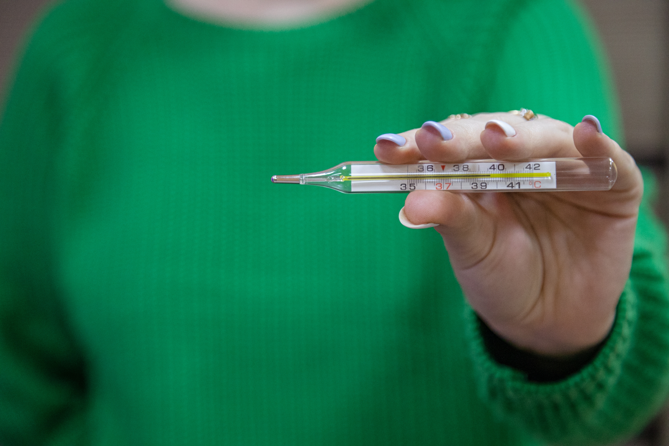 Девушка держит термометр