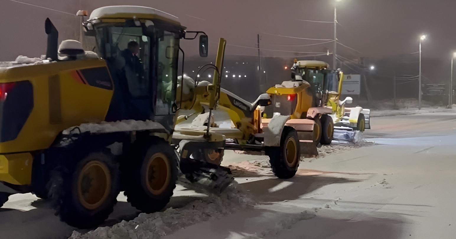 Спецтехника (грейдеры) убирает снег на ночных улицах Краснотурьинска после снегопада.