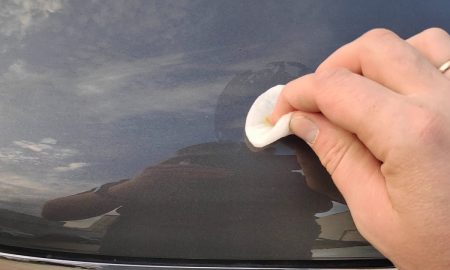 протирает кузов машины