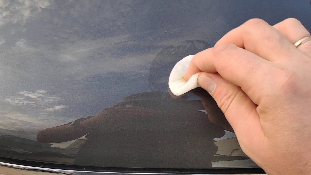 протирает кузов машины