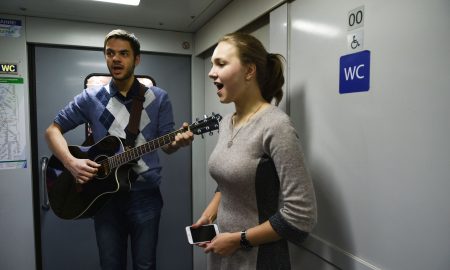 Молодые люди в тамбуре электрички.