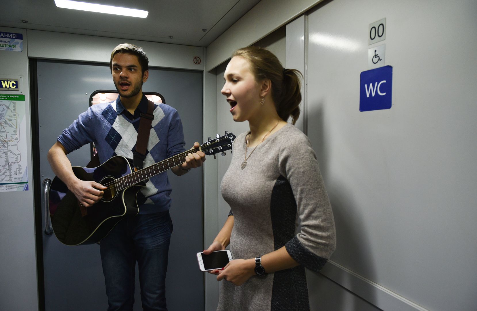 Молодые люди в тамбуре электрички.