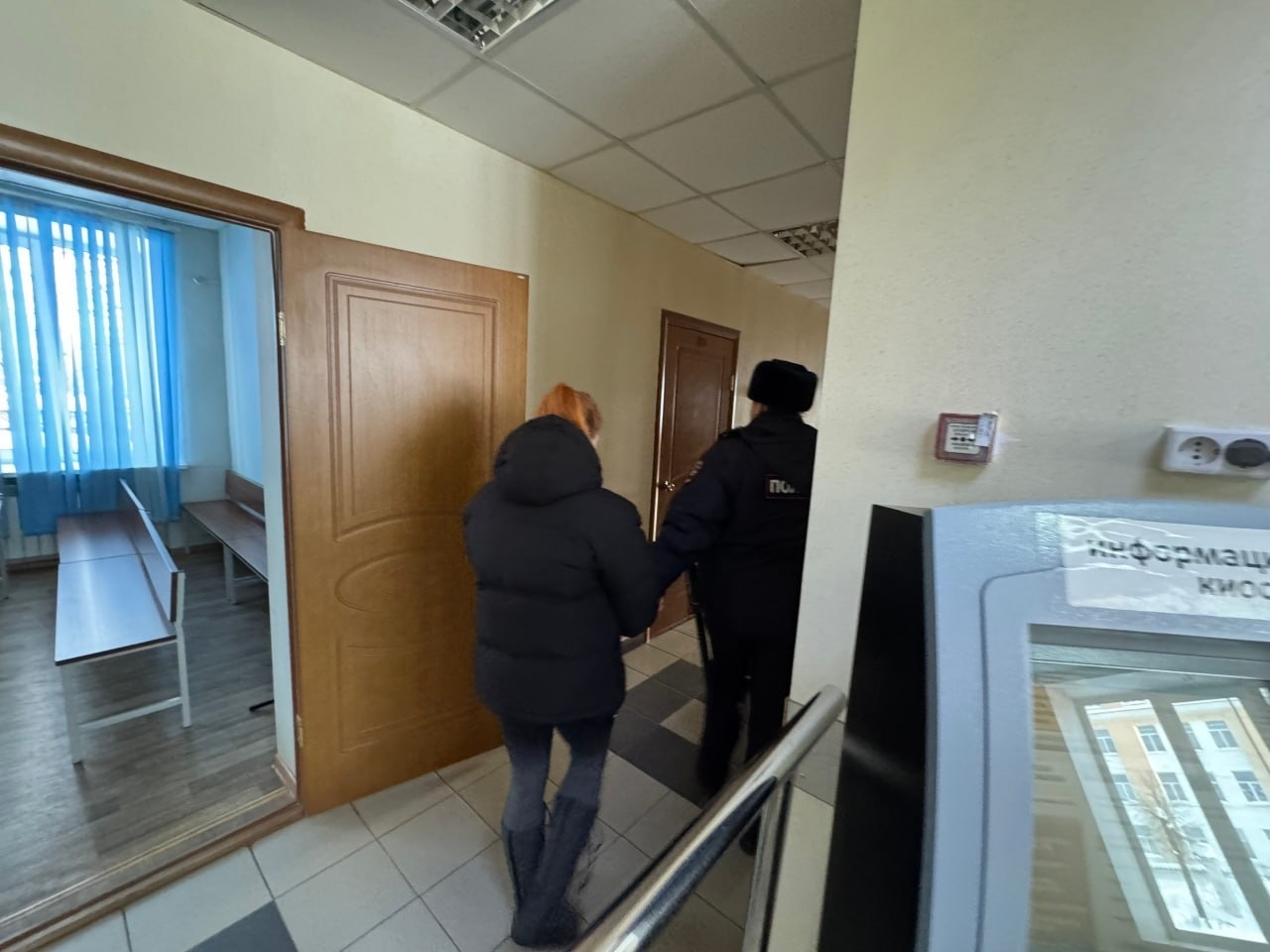 Арестованную ведут по коридору