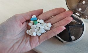 Девушка держит таблетки