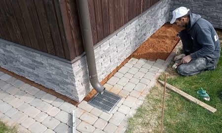 выкладывает плиты у дома