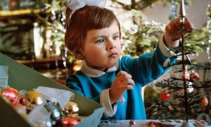 Ребенок вешает игрушки на елку