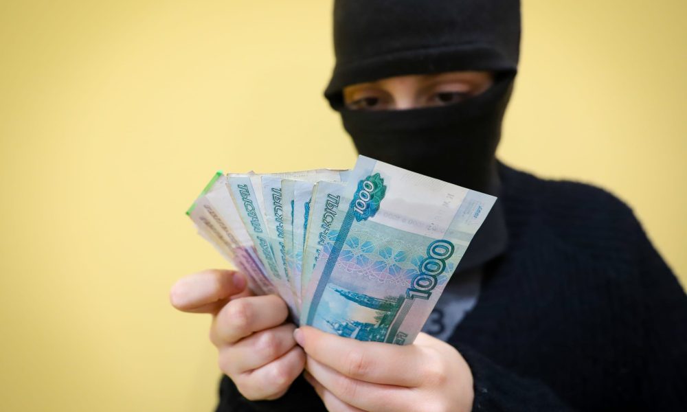 Преступник держит деньги