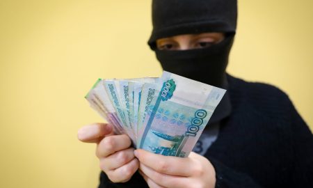 Преступник держит деньги