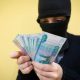 Преступник держит деньги