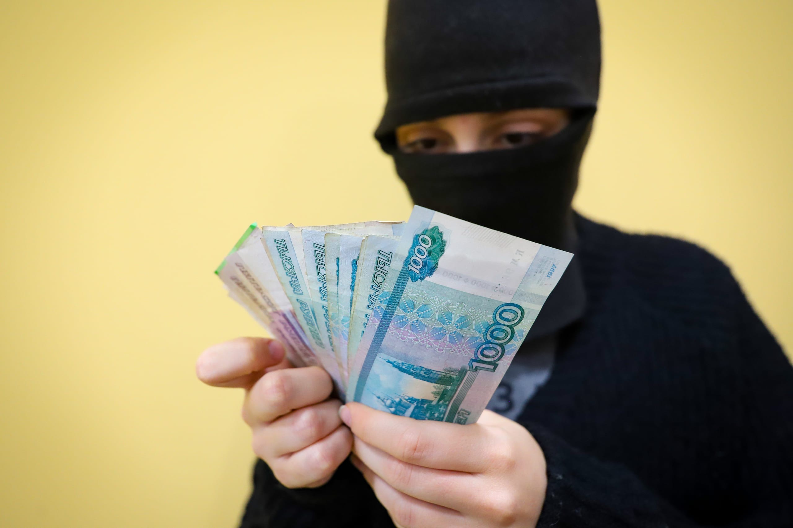 Преступник держит деньги