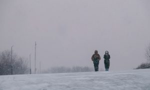 Люди идут под снегом