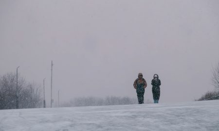 Люди идут под снегом