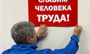 Человек вешает плакат