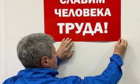 Человек вешает плакат