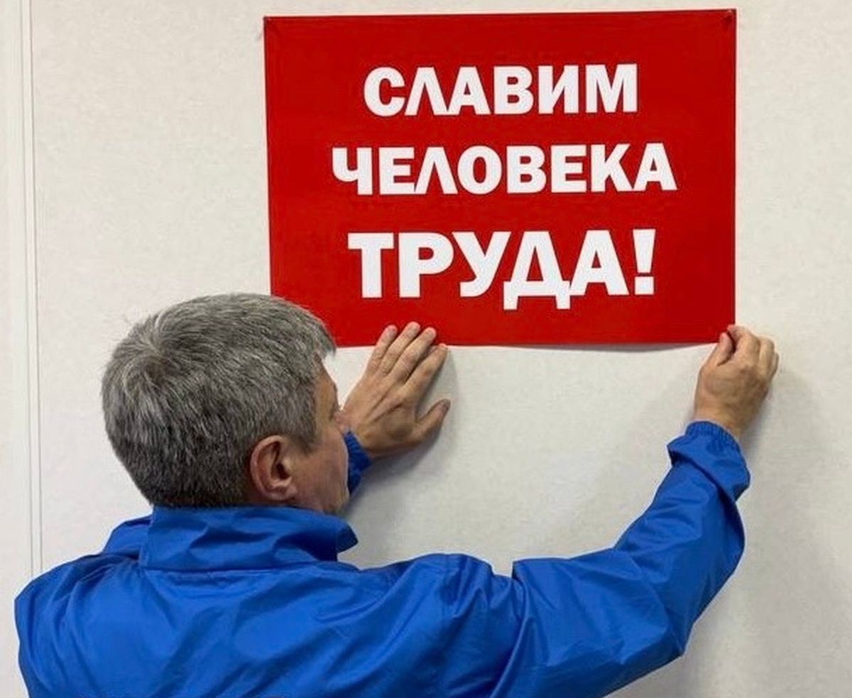 Человек вешает плакат