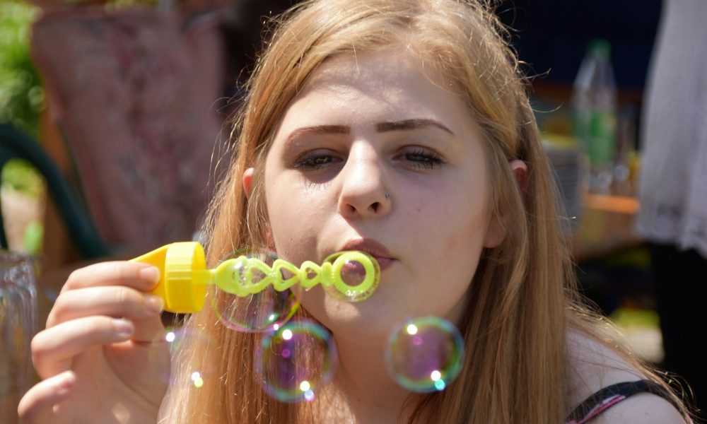 Девушка выдувает пузыри