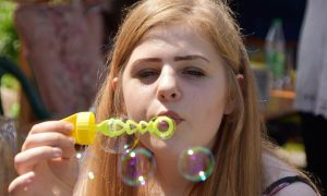 Девушка выдувает пузыри