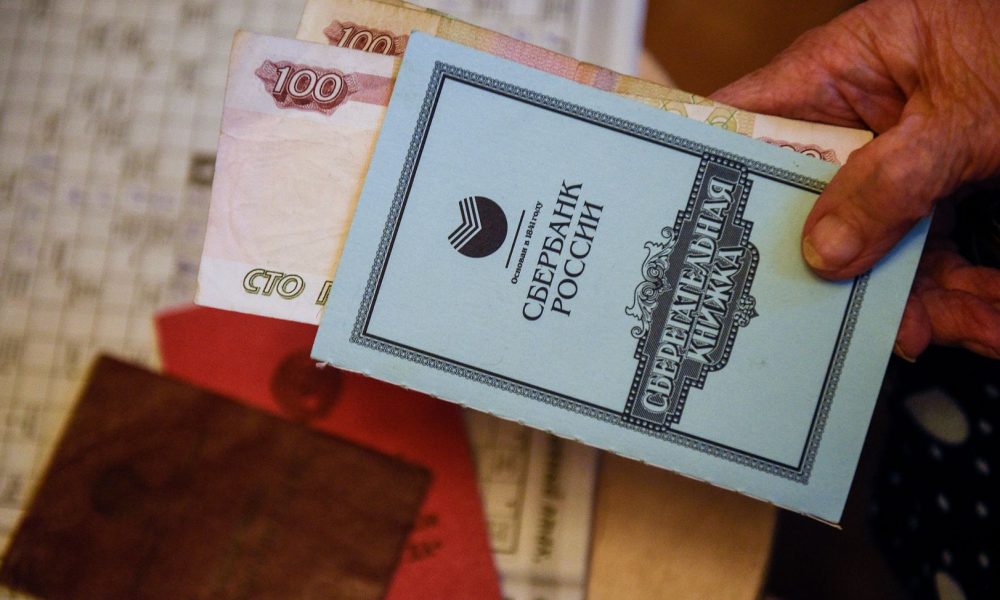 Пенсионерка с пенсионным удостверение, удостверением ветерана труда и сберегательной книжкой сбербанка России.