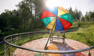 Место для отдыха участников спортивного фестиваля Майская прогулка со скамейкой и ярким цветным зонтиком.