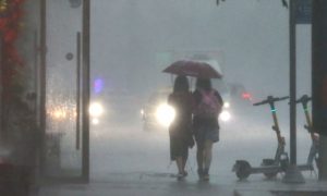 Прохожие во время сильного дождя.