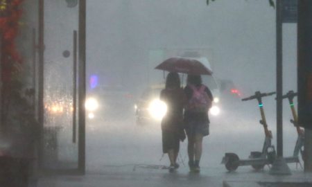 Прохожие во время сильного дождя.