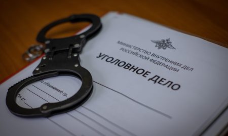 Наручники лежат на уголовном деле