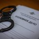 Наручники лежат на уголовном деле