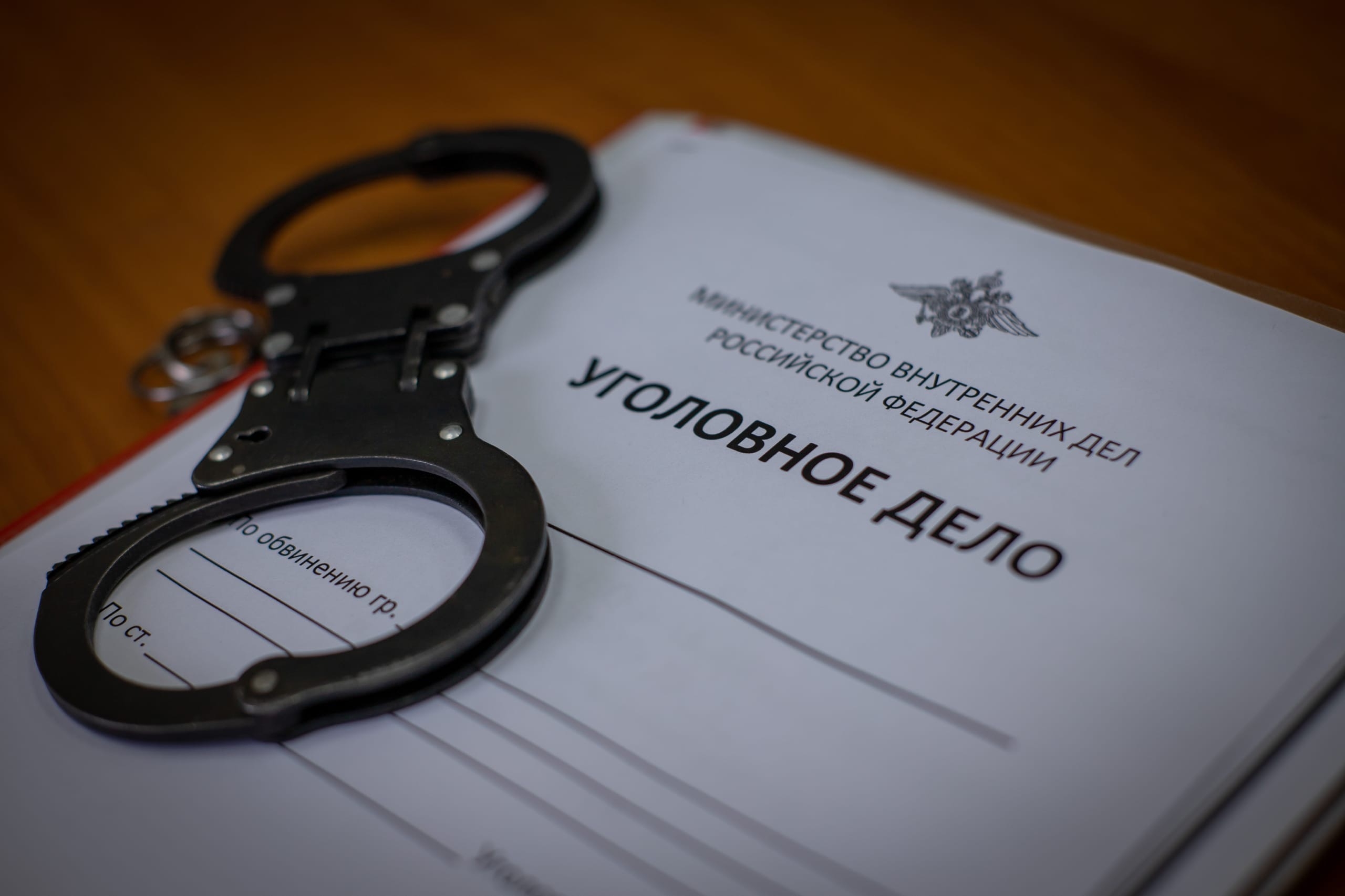 Наручники лежат на уголовном деле