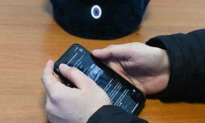 Смартфон в руках полицейского.