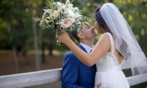 Невеста с букетом целует жениха