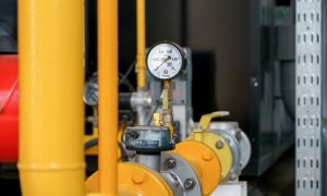 Газовый вентиль на трубе в жилом доме как символ расчетов за коммунальные услуги.