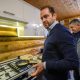 Мужчина у газовой плиты жарит яичницу