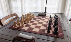 Черные и белые шахматные фигуры на деревянной доске.