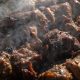 Аппетитное мясо на шампурах, жарящееся на углях в мангале на уральской даче.