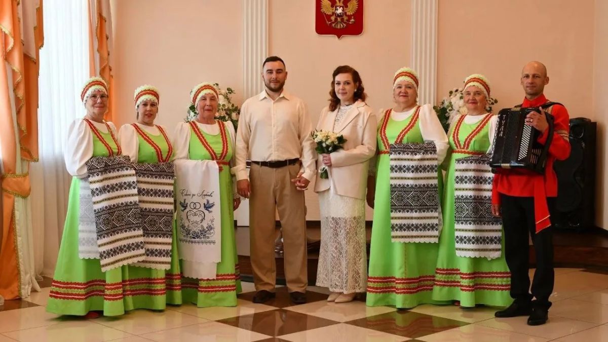Молодожены в традиционных русских народных костюмах Свердловской области во время свадебной церемонии.