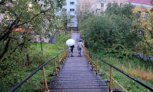Люди идут под дождем