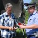 Инспектор ДПС проверяет документы у автовладельца.
