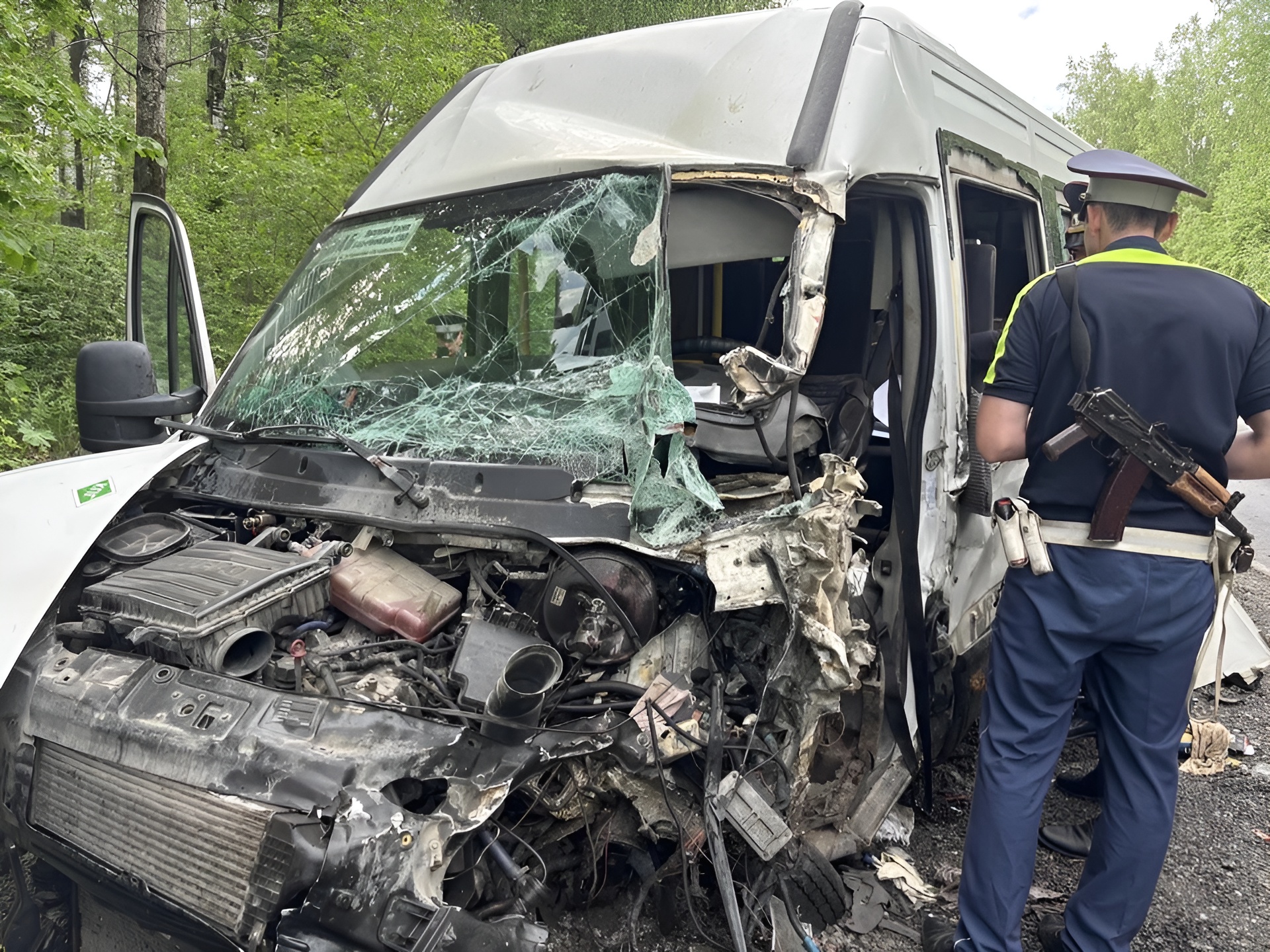 Поврежденный микроавтобус Iveco после столкновения с трактором на 281-м километре автодороги Екатеринбург — Серов. На переднем плане сотрудник полиции осматривает место происшествия.